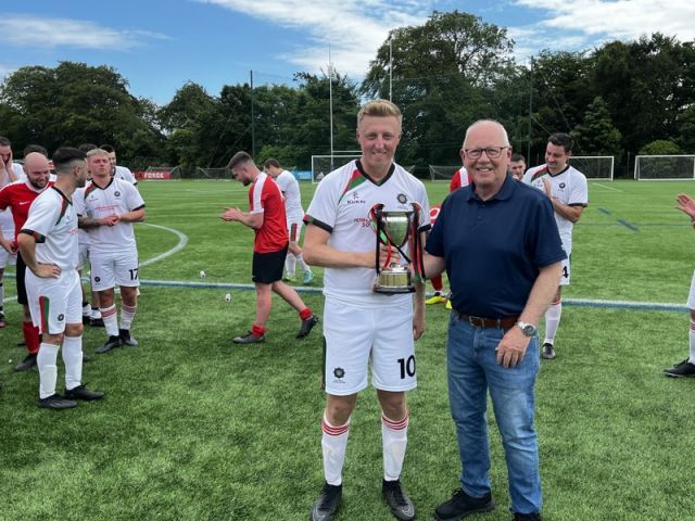 Belfast South + East captain Chris Boyd receiving the Buckley Cup from League Chairman Alan McClune