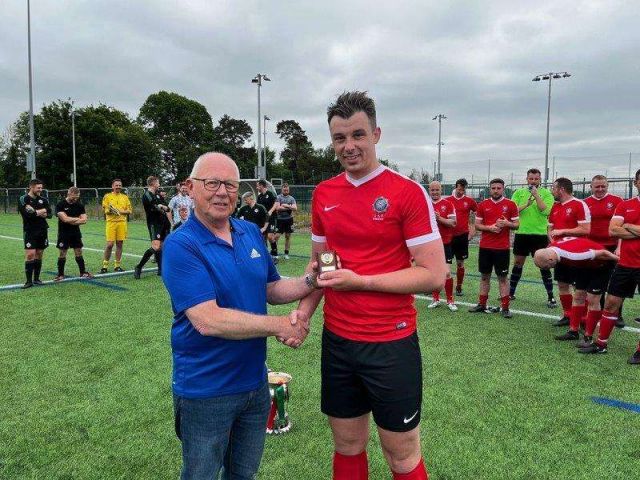 Chris Watts receiving his Man of the Match trophy from League chairman Alan McClune